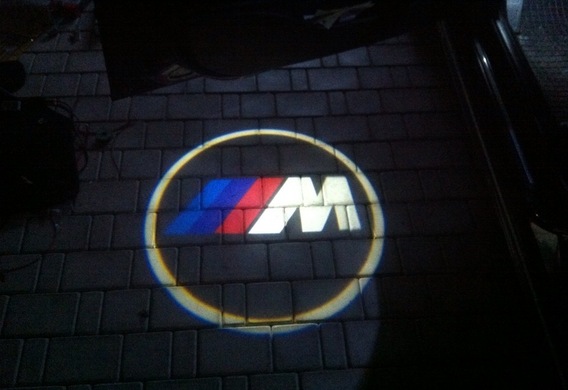A logo projection. Logo Projector on asphalt
